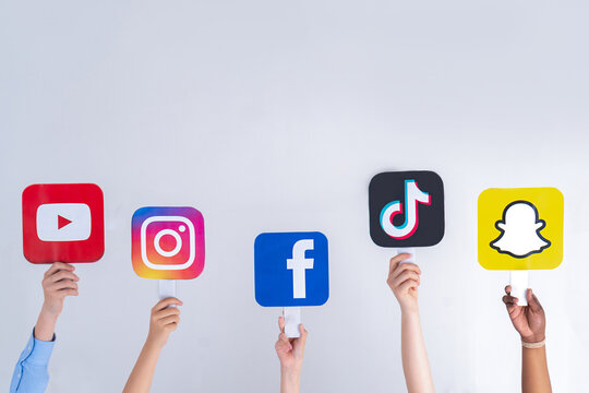 Teenagers hands hold social media signs in their hands. Teenagers addicted to new technology trends - the concept of youth, technology, social and friendship.