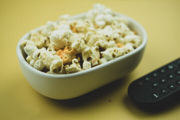Popcorn with remote control placing on the side.