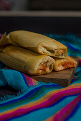 Vertical photo of rich red tamales with meat, traditional Mexican food.