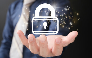 Businessman holds a padlock that protects business and information data via a virtual network connection. Innovation technology creates smart solutions to protect against digital attacks.