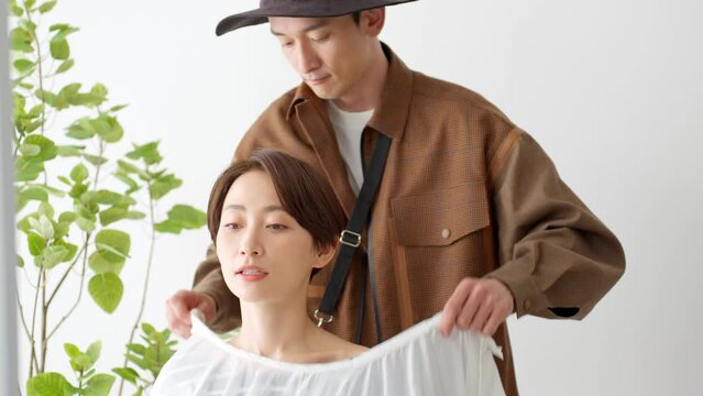 ケープをかけ髪を確認する美容師とお客さま