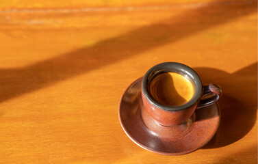 The morning cup of espresso coffee with beautiful tiger crema on the wooden table rustic background
