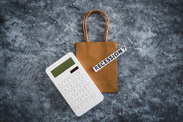 recession text over shopping bag next to calculator