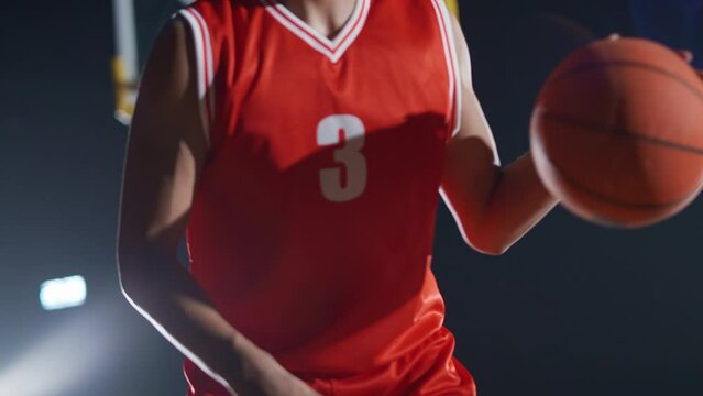 Portrait of an asian man basketball player, hits the ball on the floor and serious looking at the camera, basketball championship, 4k slow motion.