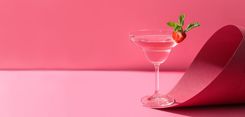 Glass of tasty cosmopolitan cocktail on pink background with space for text
