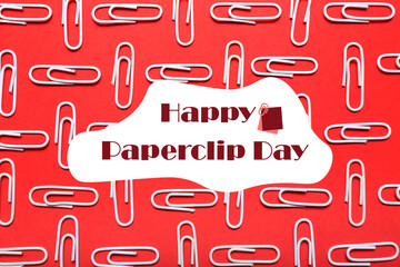 Many paperclips on red background. Greeting card for National Paperclip Day