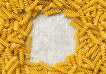 Uncooked pasta laid out on a table with space in the center