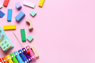 Children building blocks with xylophone on pink background