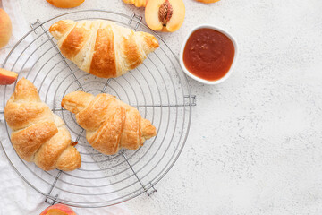 Grid of delicious croissants with peach jam on white background