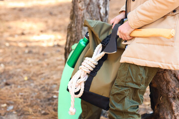 Fototapeta premium Male tourist with backpack and survival kit in forest