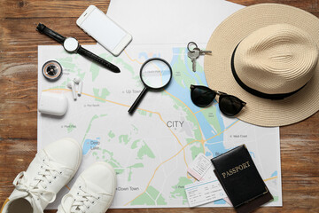 Guide's belongings with city map on wooden background