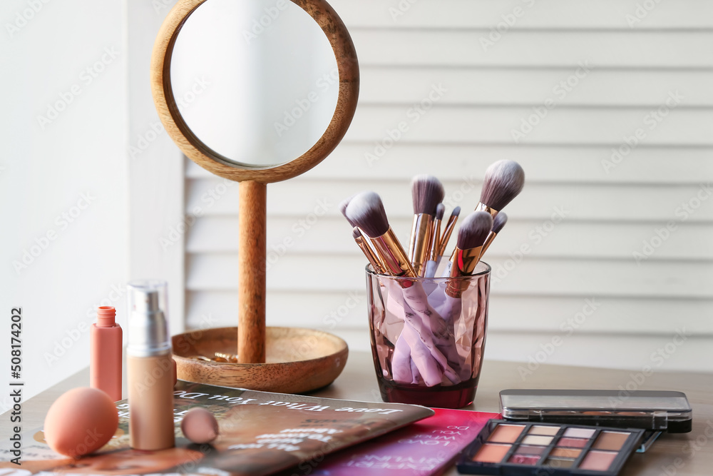 Sticker Holder with makeup brushes, cosmetic products and magazines on table in room