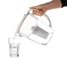 Woman pouring purified water into glass from filter jug on white background