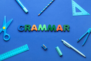 Word GRAMMAR and stationery supplies on blue background