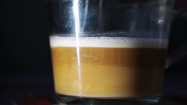 Coffe transparent glass mug. Latte creamy cup. Espresso and milk drink. Liquid beverage on table. Slow motion video. Home breakfast
