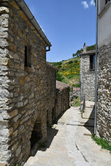 Obraz premium A narrow street between the old houses of Sasso di Castalda, a village in the mountains of Basilicata, Italy.