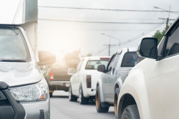 Front of silver car driving on the asphalt road on days. with other cars driving in the opposite direction during heavy traffic.