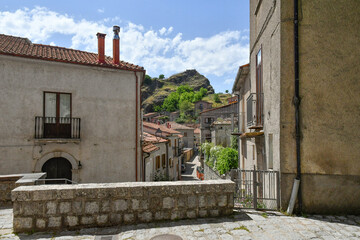 Obraz premium A narrow street between the old houses of Sasso di Castalda, a village in the mountains of Basilicata, Italy.