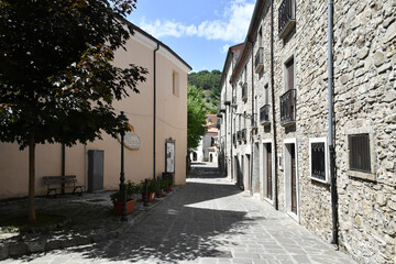 A narrow street between the old houses of Sasso di Castalda, a village in the mountains of Basilicata, Italy.