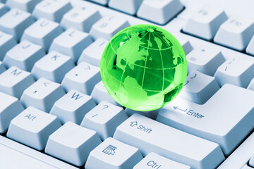 Green crystal globe of the Earth on a computer keyboard