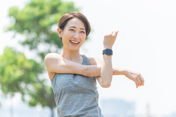 新緑の中でストレッチをする日本人女性