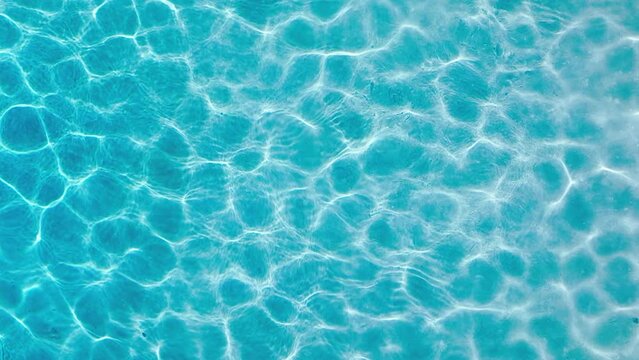 Water surface texture, Slow motion clean swimming pool ripples and wave, Refraction of sunlight top view texture sea side, sun shine water background. Water Caustic Background 4K aerial