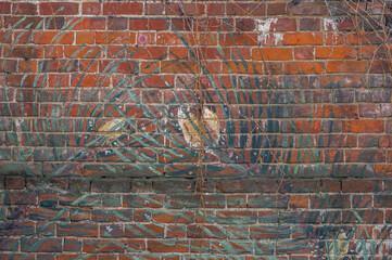 Brick red wall with pattern and bushes