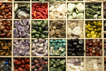 Variety of many beautiful colorful stones,small rocks of different colors in wooden box.View from top. Natural background