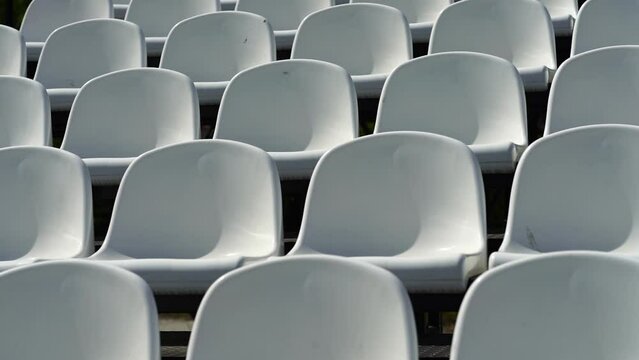 Empty seats of modern stadium, white chairs. Tribune seats in a sports stadium.