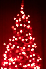 Christmas tree in lights on red background- soft focus and bokeh