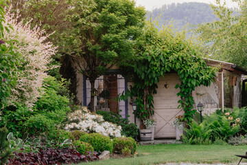 Fototapeta na wymiar Altanka, domek ogrodowy zanurzony w pieknym zielonym ogrodzie