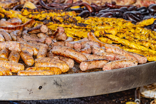 Varied meat grill, with pork, chicken skewers, sausages and chorizos, selective focus on the sausage at the bottom right of the image.