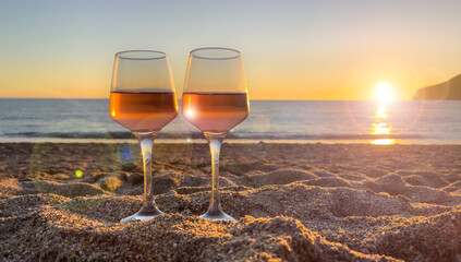 wineglasses on the beach at sunset