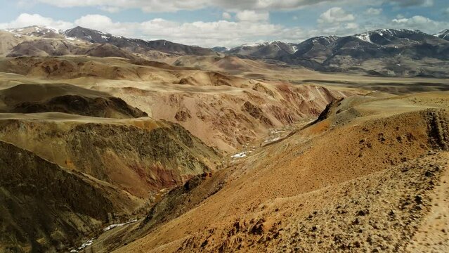 Exotic mountain landscape. Blue skies over mountain peaks covered with snow. Aerial survey of mountains in 4K.