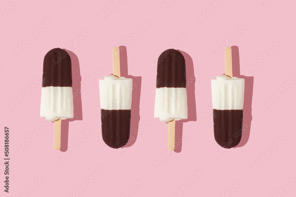 Wall mural Summer creative pattern with ice cream popsicles  on pastel pink background.  70s, 80s or 90s retro aesthetic fashion idea. Minimal summer idea.