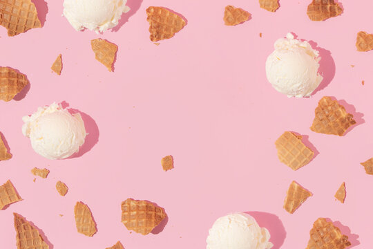 Summer creative layout with broken ice cream cone pieces and ice cream scoops on pastel pink background. 80s or 90s retro fashion aesthetic ice cream and scoop concept. Minimal  summer idea.