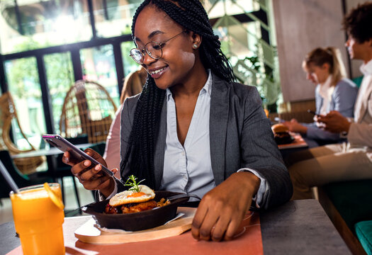 African American businesswoman having lunch in restaurant.