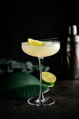 Daiquiri cocktail in a beautiful glass with a slice of lime and crushed ice. Tropical alcoholic drink with rum