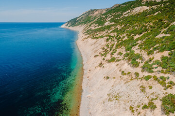 Coastline with quiet sea and highest cliff on coastline. Summer day on sea. Aerial view