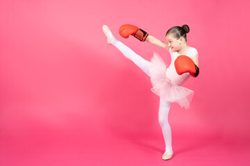 Little ballet dancer girl practicing karate. Child wearing tutu and boxing gloves isolated on vivid...