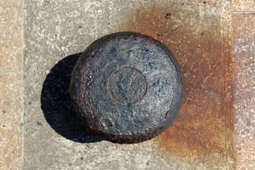 Image of the rusty bollard of the harbor taken from directly above.