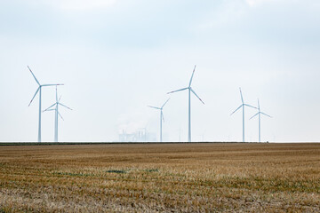 Crops with windmills and power plant on the horizon.