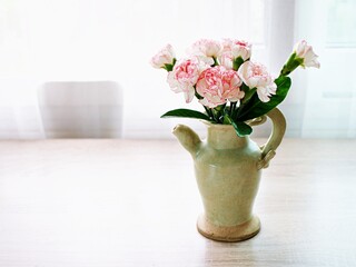 Pink white pastel Dianthus Carnation flowers in vase on embroidered Clove pink still life for...