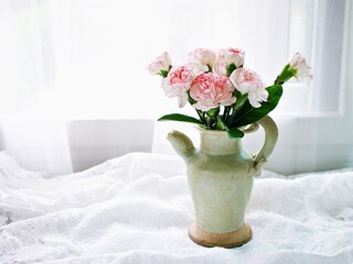 Pink white pastel Dianthus Carnation flowers in vase on embroidered Clove pink still life for background or wallpaper text letter ,mother's day ,women's day soft color romantic love tone copy space 