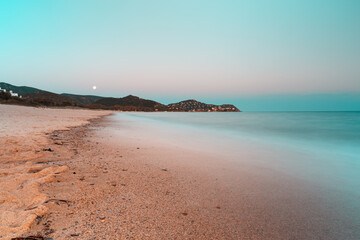 Panoramic long exposure view of the beach of Kal'e moru at sunset blue hour with full moon