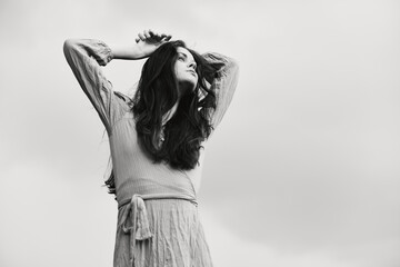 woman in dress gesturing with hands posing black and white photo