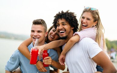 Friends having fun together at the beach and drinking a cold beer