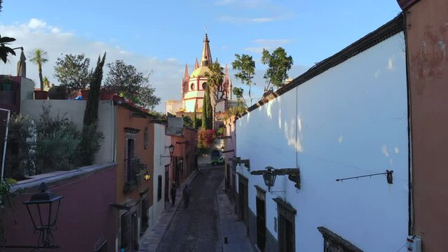 Aerial Drone Shot From Narrow street in San Miguel de Allende Cathedral at evening light in Guanajuato, Mexico.