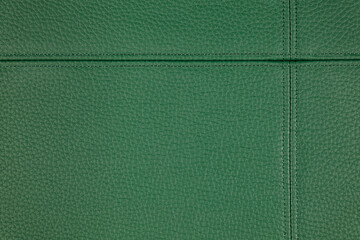 Natural, artificial green leather texture background with decorative seam. Material for sport...