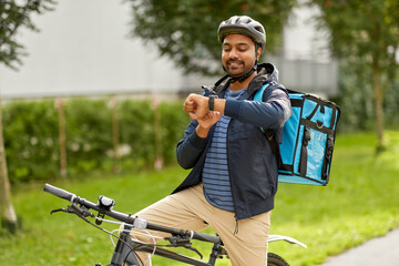 food shipping, profession and people concept - happy smiling delivery man with thermal insulated...